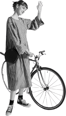 A person waving next to their bicycle